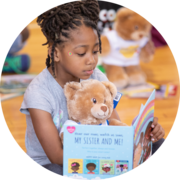 Build-A-Bear girl reading a book to a teddy bear